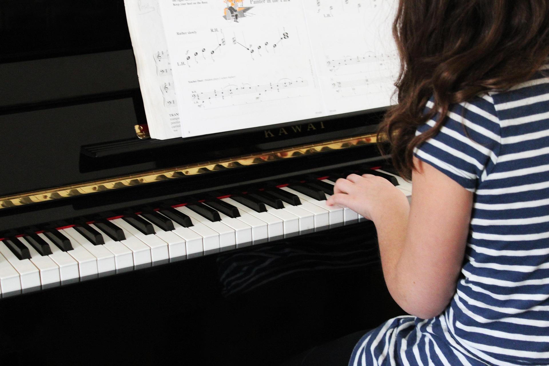 Student practicing piano during a private lesson